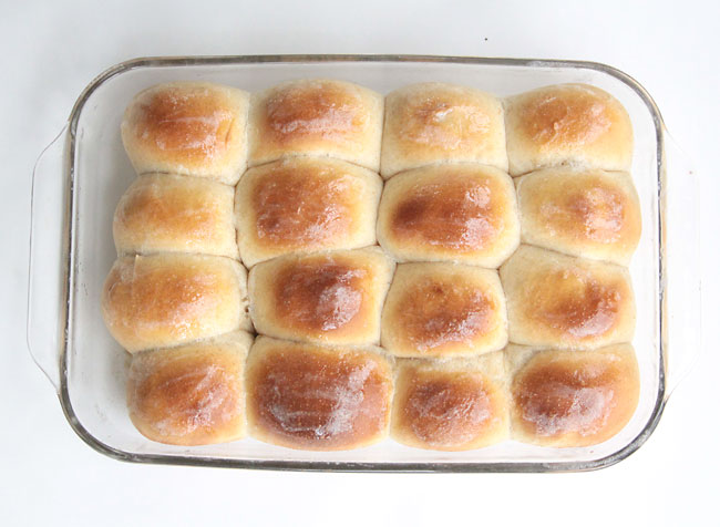 Golden brown homemade dinner rolls in a 9x13 glass pan