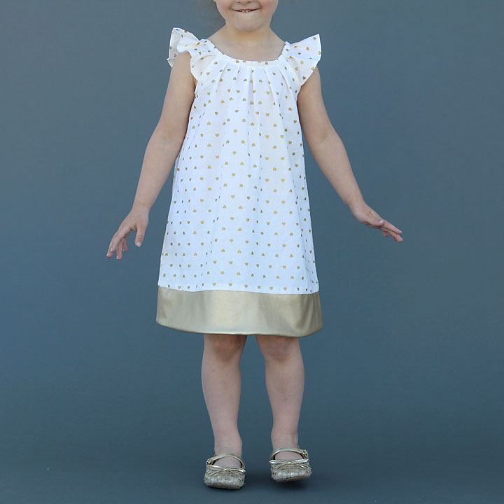 A girl wearing a flutter sleeve dress with pleated neckline