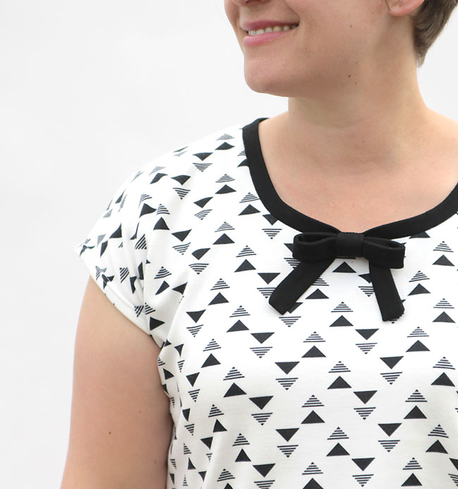 A woman in a t-shirt with a small bow at the neckline