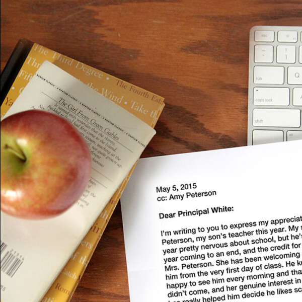 Letter to a principal next to books with an apple on top