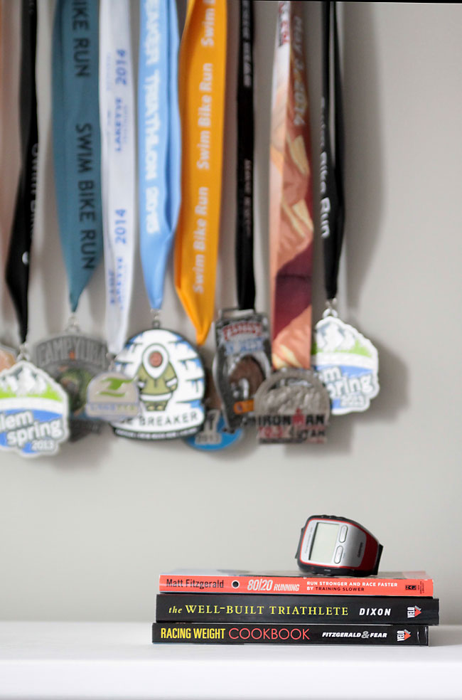 medals hanging on a wall, with books and watch