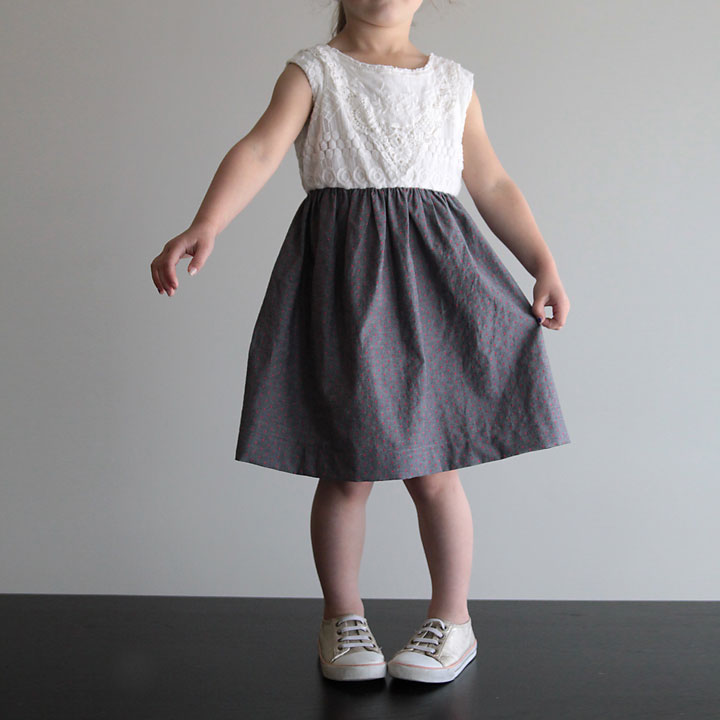 A little girl wearing a dress with gathered skirt