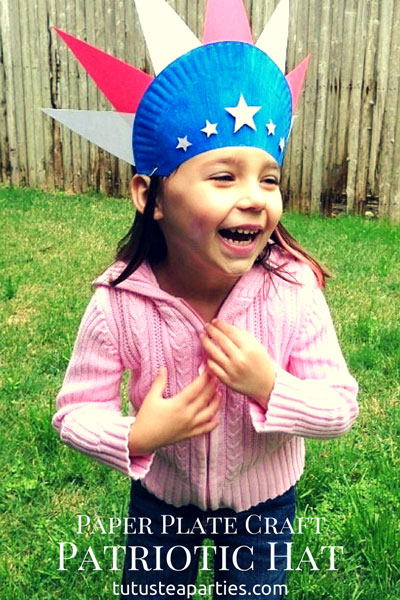 A little girl wearing a paper plate 4th of July hat