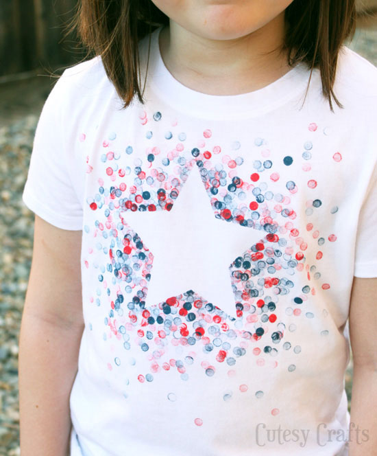 A little girl wearing a 4th of July t-shirt with a white star and red and blue dots
