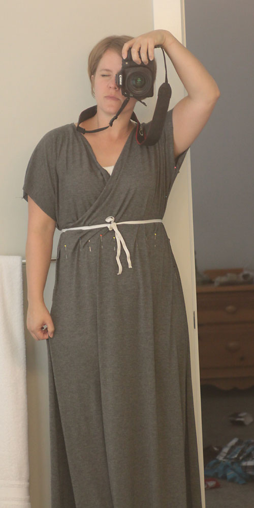 A woman wearing a criss cross maxi dress with elastic tied around the waist 