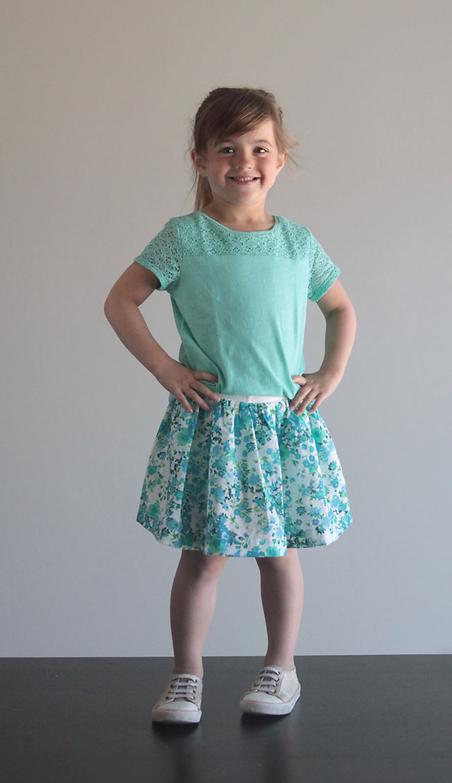 A young girl in a blue floral skirt