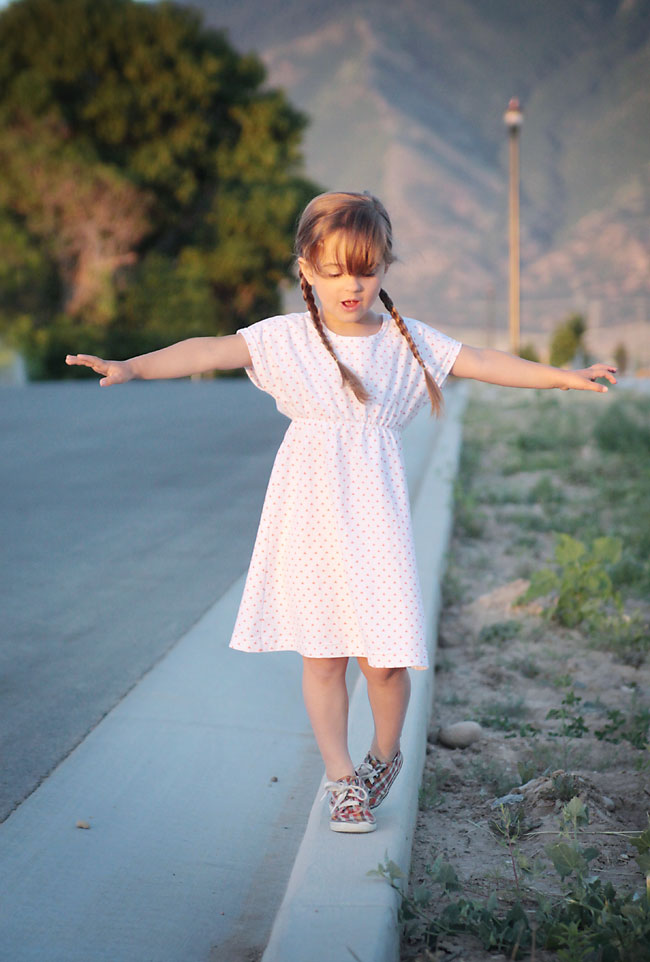 A young girl walking down the road in a play dress