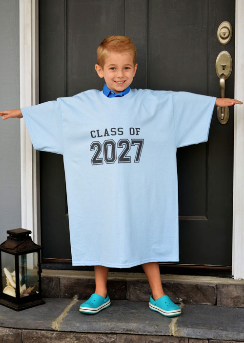 A young boy in a big blue shirt that says class of 2027
