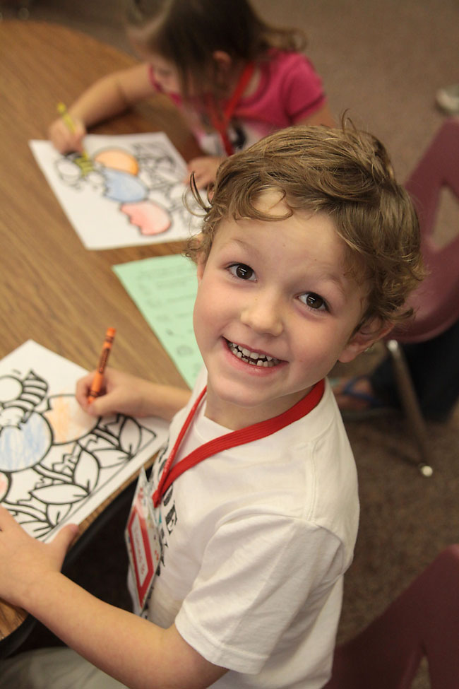 A small child sitting on a table at kindergarten