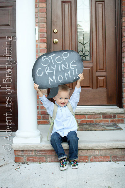 Little boy holding sign that says stop crying mom!