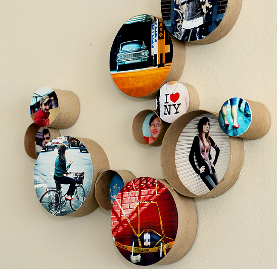Circular photos framed with cardboard rolls hanging on a wall in a group