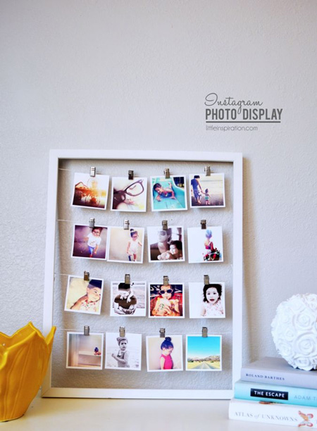 Frame with photos hanging from strings that go across the width of the frame