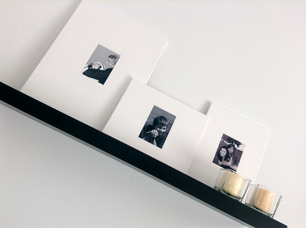 Black and white photos on larger canvases on a shelf