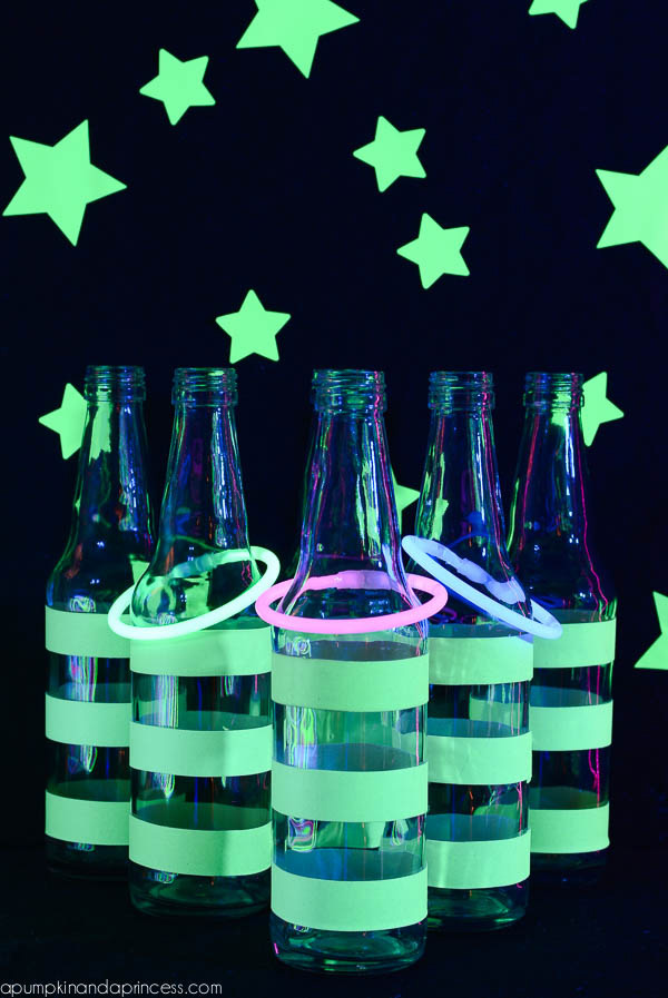 Bottles wrapped in glow in the dark paint with glowing bracelets tossed over them