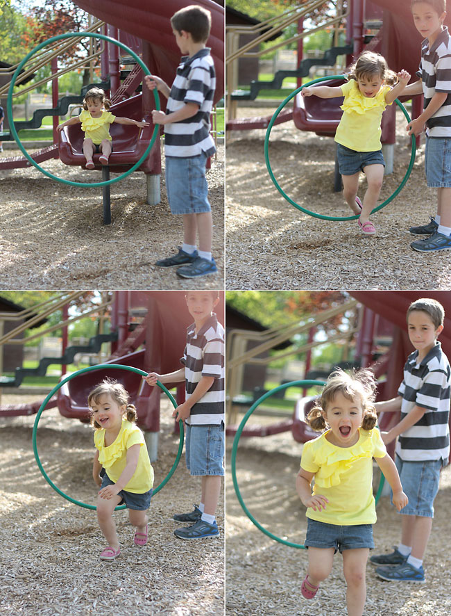 Little girl coming down a slide and hopping through a hola hoop