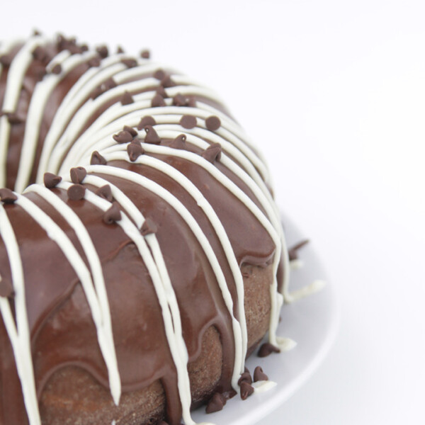 A large chocolate cake on a plate with Cream cheese frosting