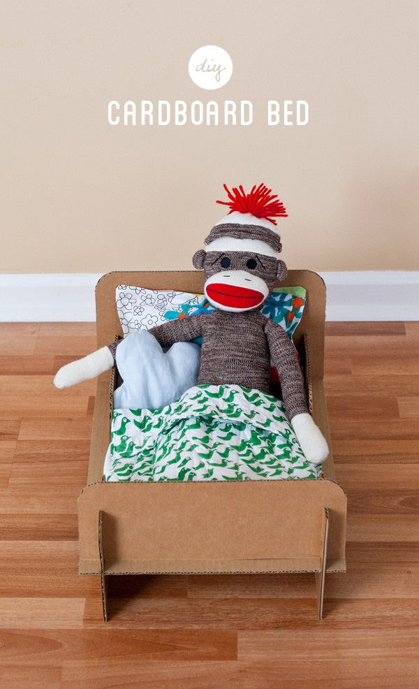Stuffed animal in a toy bed made from cardboard