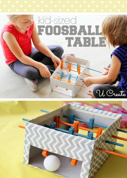 Kids playing with a foosball table toy you can make from cardboard box