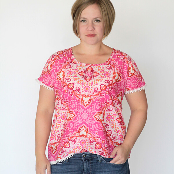 A woman wearing a pink blouse made from a sewing tutorial