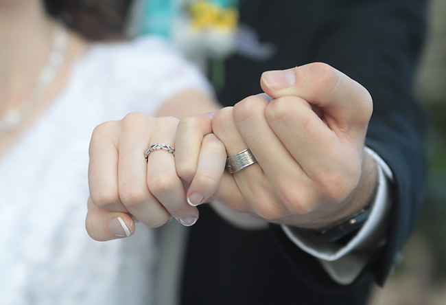 A close up of a bride and grooms hands and wedding rings