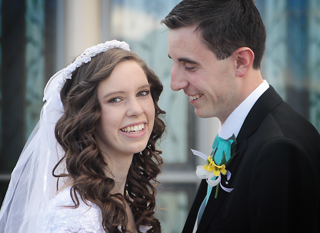 Groom is looking at bride who looks at the camera