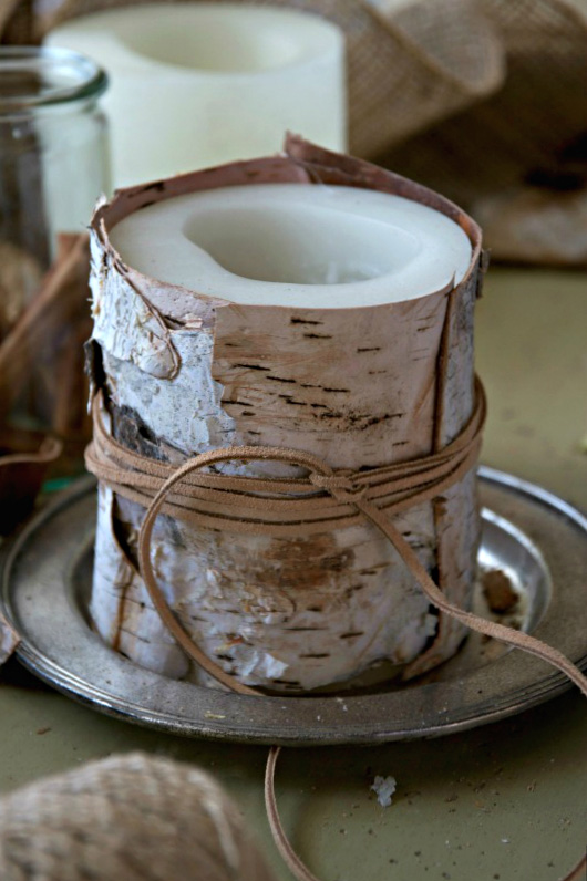 A candle wrapped in birch bark and tied with leather twine for a handmade gift