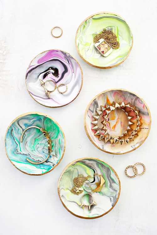 A close up of a pretty marbled ring dishes with jewelry in them