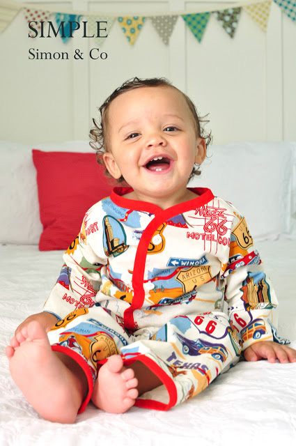 A small child sitting on a bed wearing pajamas