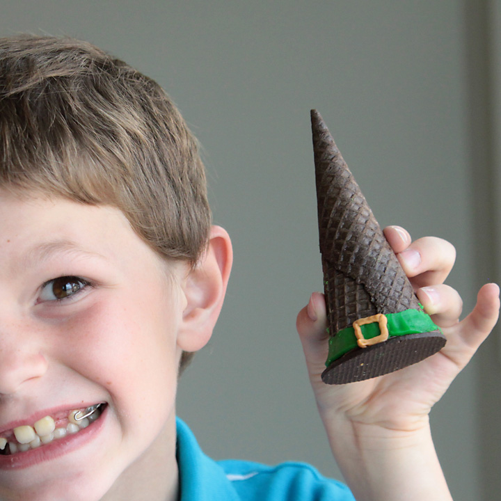 Boy holding a witch hat cookie