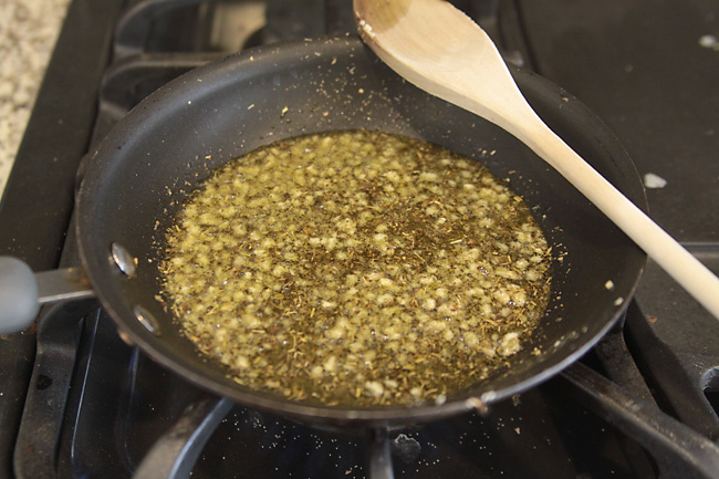 Oil, herbs and garlic in a skillet on the stove