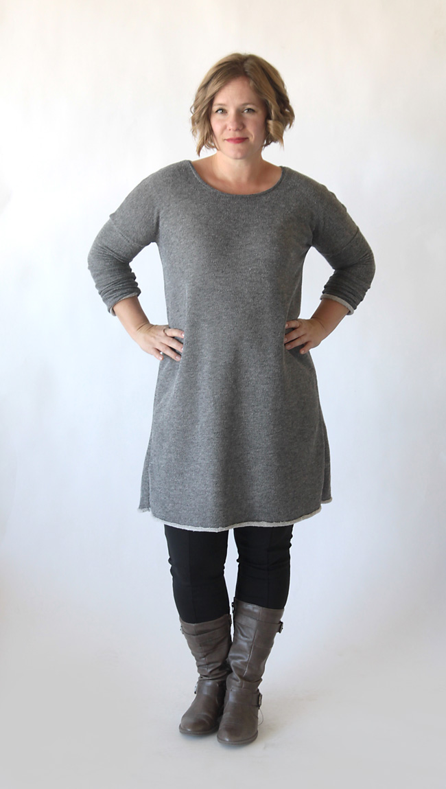 a woman wearing a grey sweater dress with leggings and boots