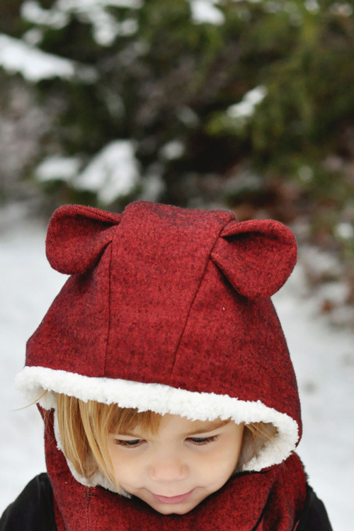 A little girl wearing a teddy bear hat