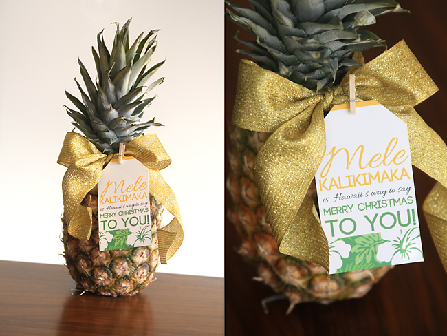 A pineapple on a wooden table with a gift tag for Christmas