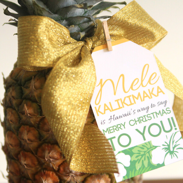 A pineapple with a Christmas gift tag on a table