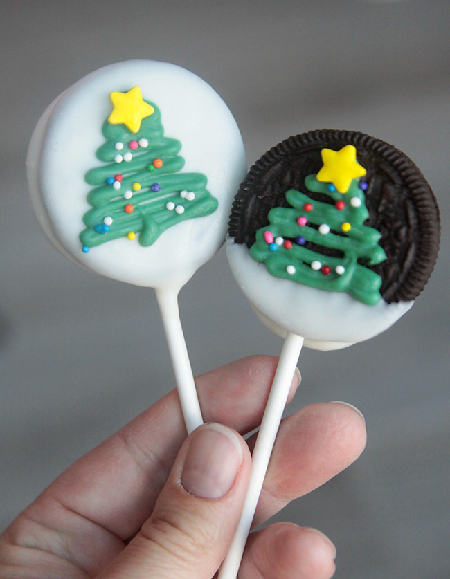 Oreo pops with Christmas trees drawn on in green candy melts with sprinkles and candy star