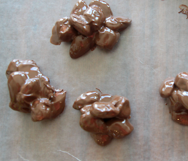 Chocolate covered almonds and marshmallows dropped onto wax paper