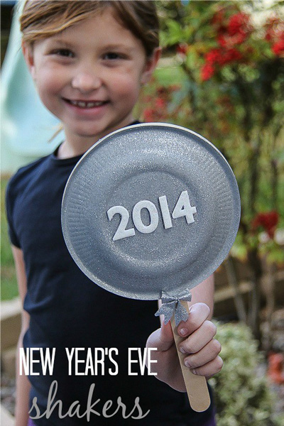 Girl holding a New Year\'s Eve shaker made from paper plates and popsicle stick