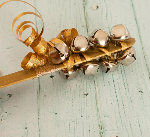 New Year\'s Eve shaker: popsicle stick with bells and ribbon