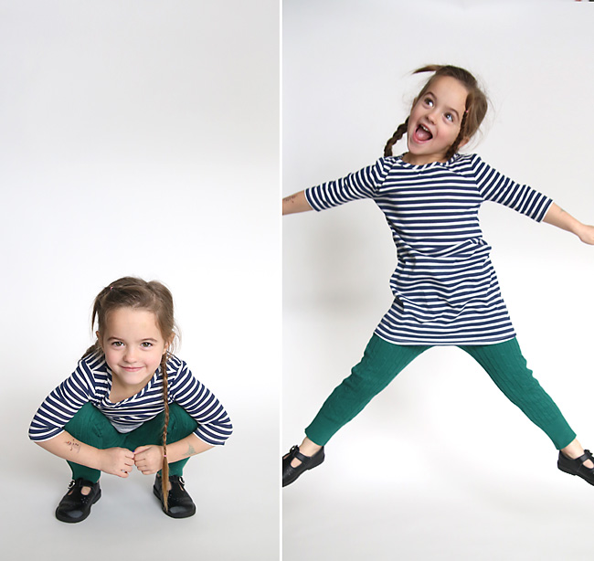 A little girl in sweater leggings jumping around