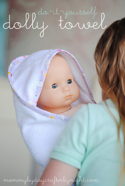 Girl holding a doll in a hooded towel