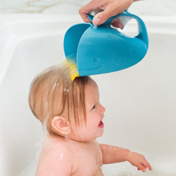 A little girl in a bath, parent using special pitcher to pour water on her hair without it going in her face