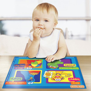 A little boy sitting at a table eating food, with adhesive placement to keep the table clean