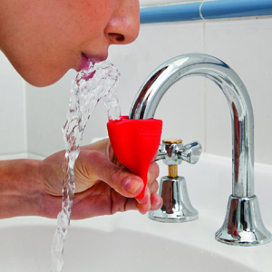 Red attachment on a bathroom faucet that can turn the faucet into a drinking fountain