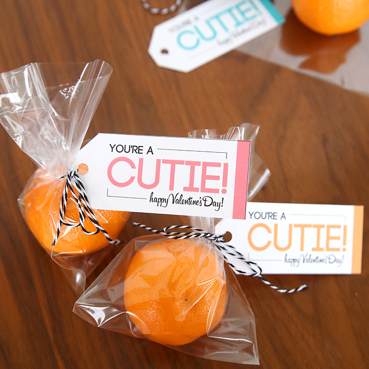 Small oranges in a bags with a tag that says \"you\'re a cutie\" for a healthy Valentines treat