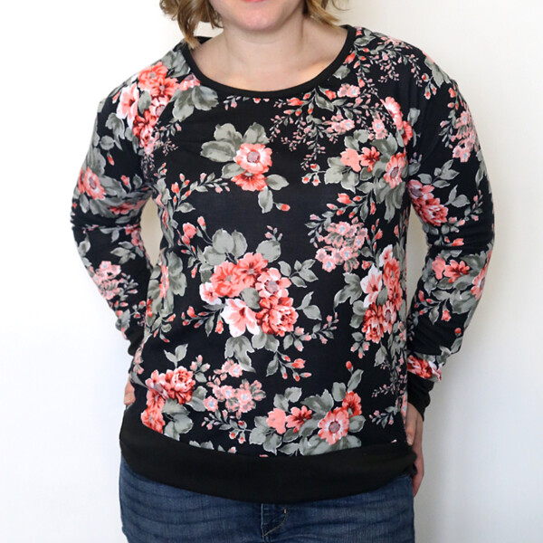 A woman wearing a black sweatshirt with pink flowers