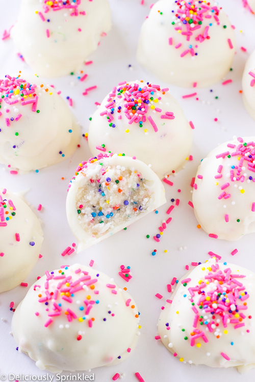 Cake batter truffles covered in white chocolate and pink sprinkles