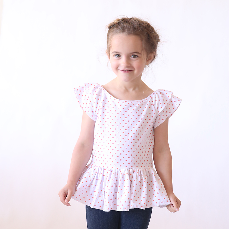 A little girl wearing a flutter sleeve top that was made from a free sewing pattern