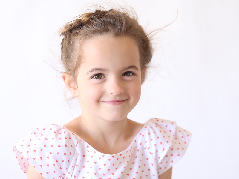 A young girl wearing a ruffle sleeve top