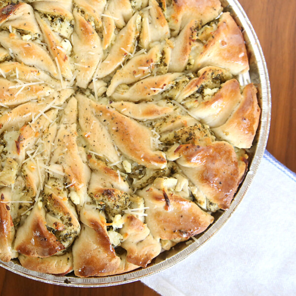 Twisted bread filled with pesto and chicken in a pizza pan