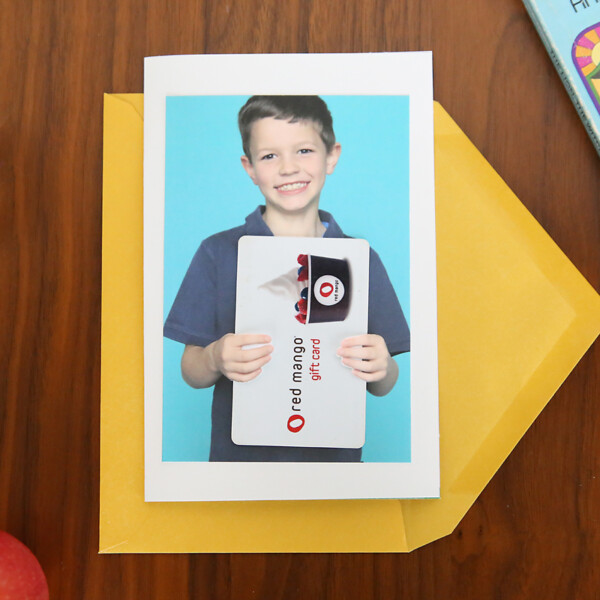 a photo of a boy holding a gift card